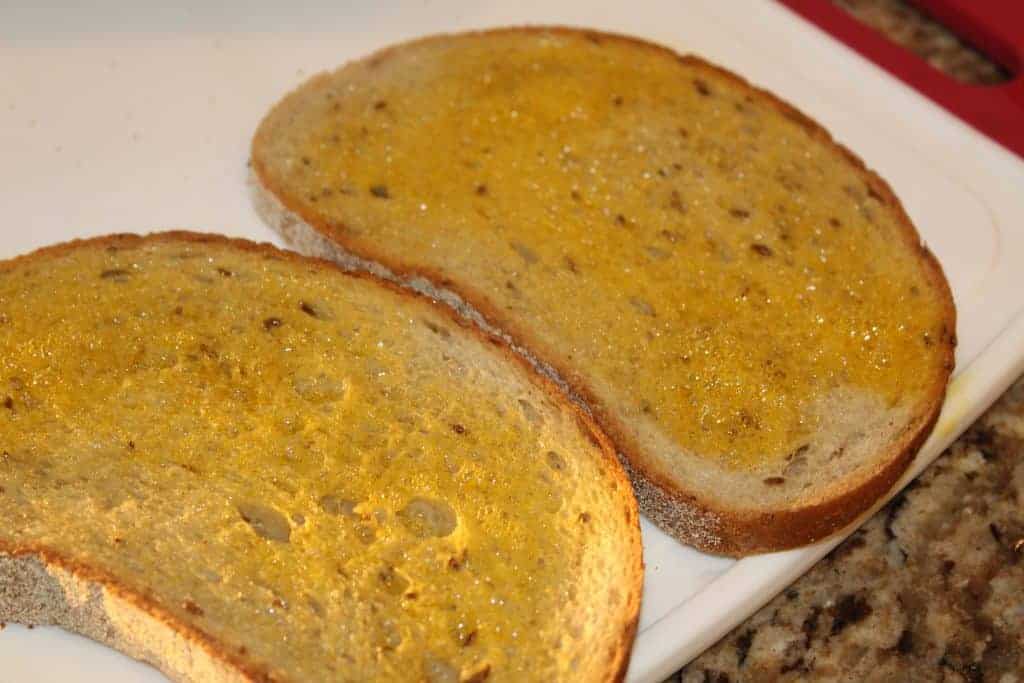 slices on bread smeared with oil on white cutting board