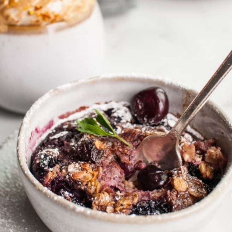 Cherry Oatmeal Breakfast in bowl, cooked with a spoon