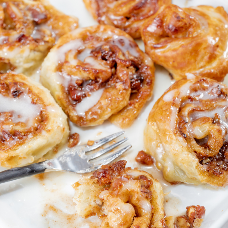 Freshly made Air Fryer Puff Pastry Cinnamon Rolls arranged on plates, showcasing their flaky layers.