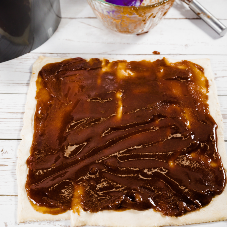 "Rolling out puff pastry dough for cinnamon rolls."