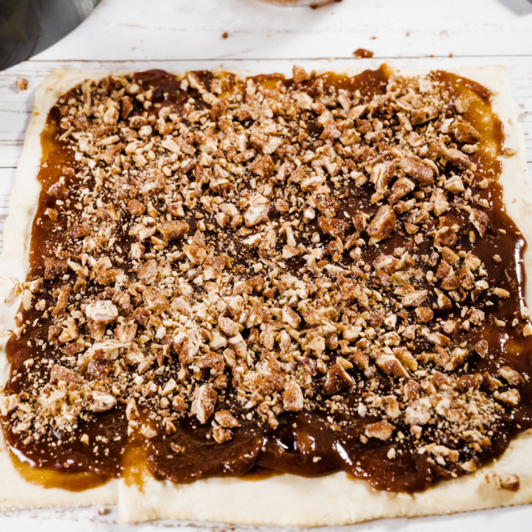 Sprinkling brown sugar and cinnamon on puff pastry.