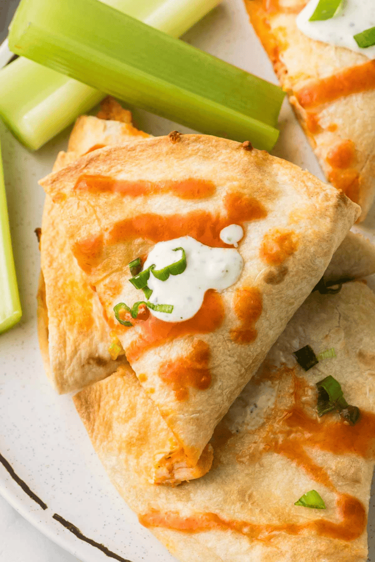 Close-up of air fryer chicken quesadilla sliced into triangles with melted cheese and spicy chicken filling.