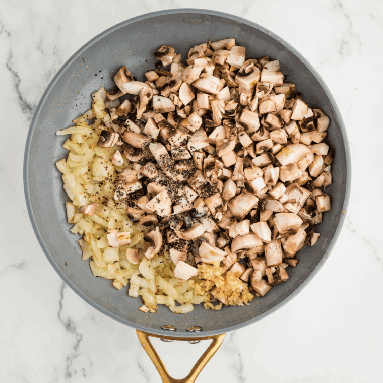 Cooking diced onions, mushrooms, and garlic in olive oil until soft and fragrant in a skillet.