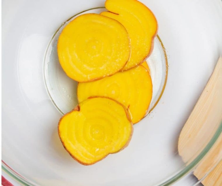 overhead: sliced golden beets in a bowl to make air fryer vegetable chips