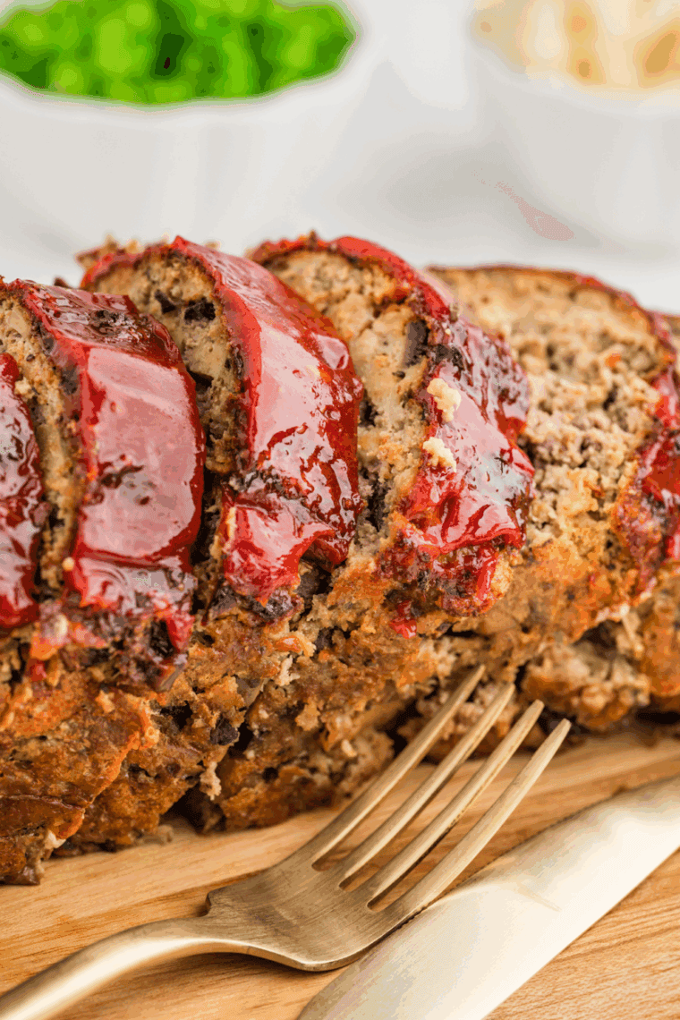 Air fryer turkey meatloaf sliced on a plate with vegetables and mashed potatoes.