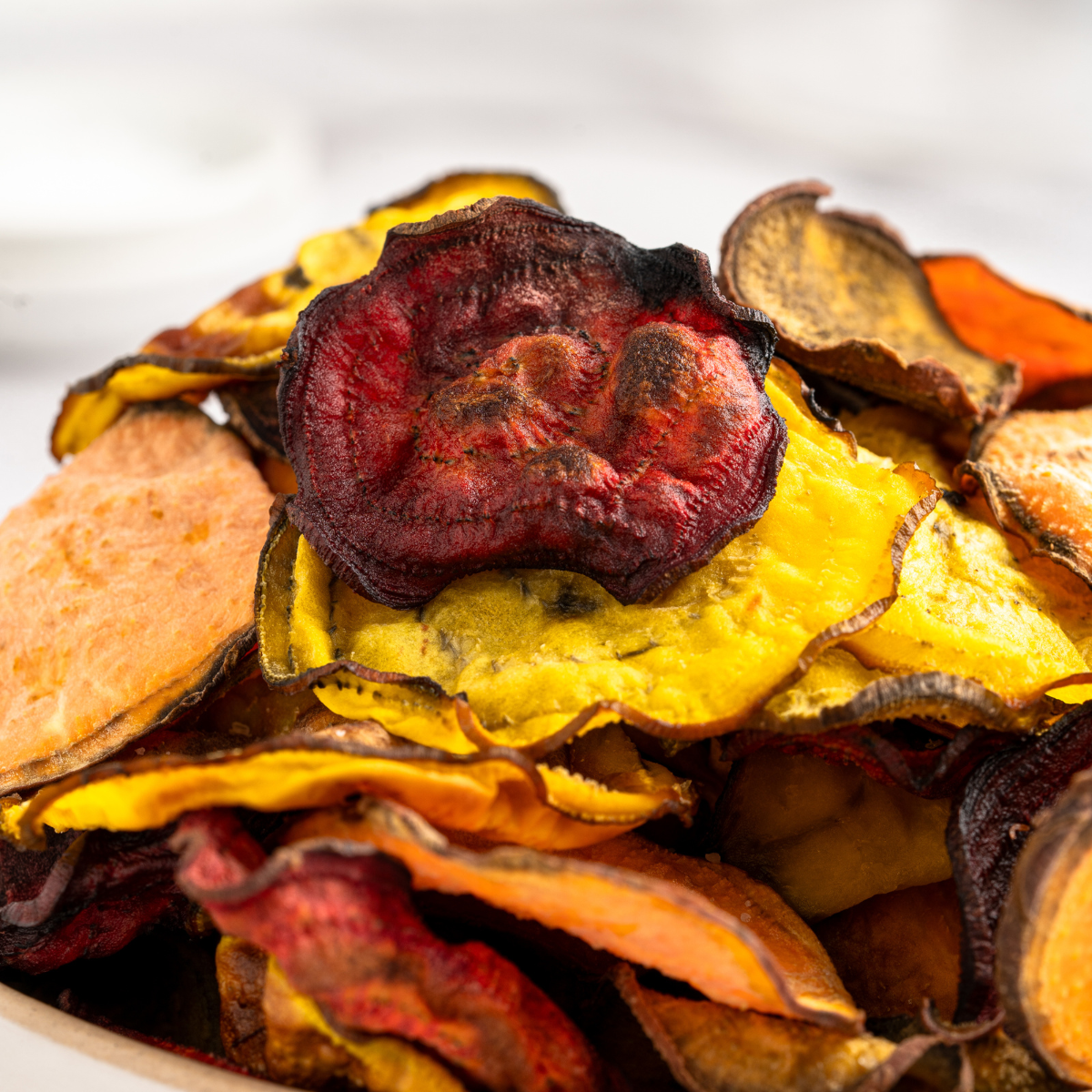 Air Fryer Copycat Terra Vegetable Chips made from colorful root vegetables served on a rustic platter.