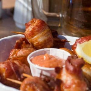 plate of bacon wrapped scallops with sauce