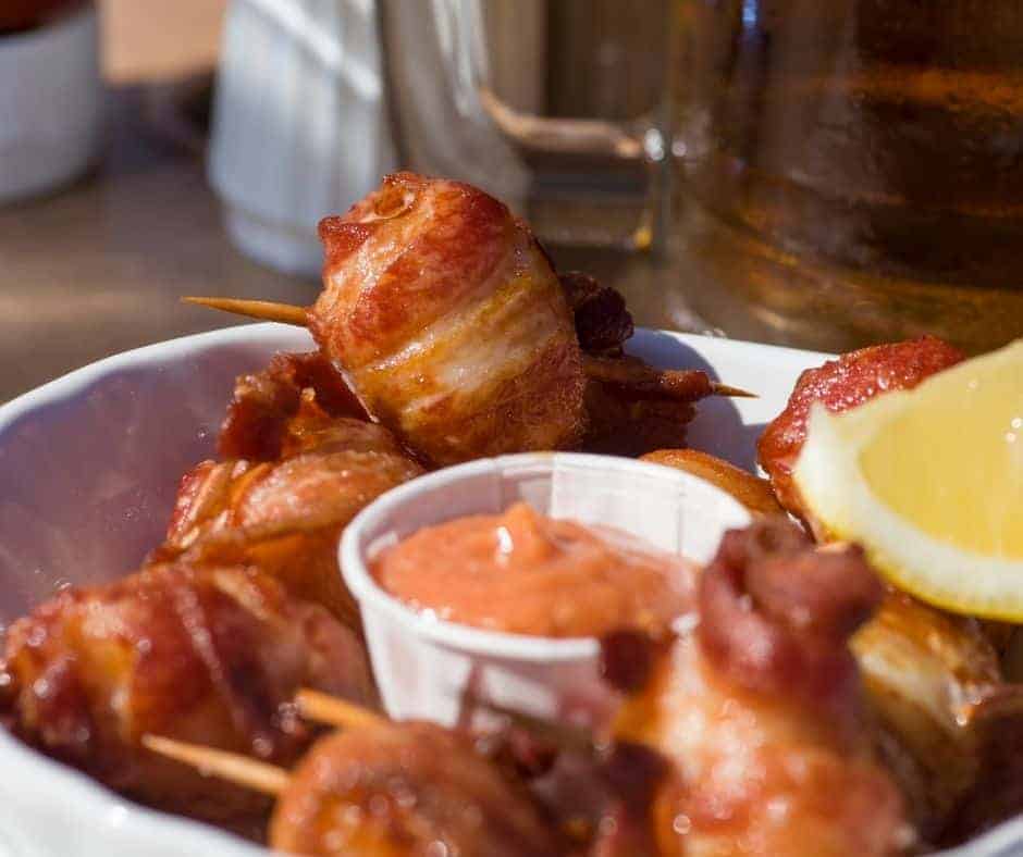 plate of bacon wrapped scallops with sauce