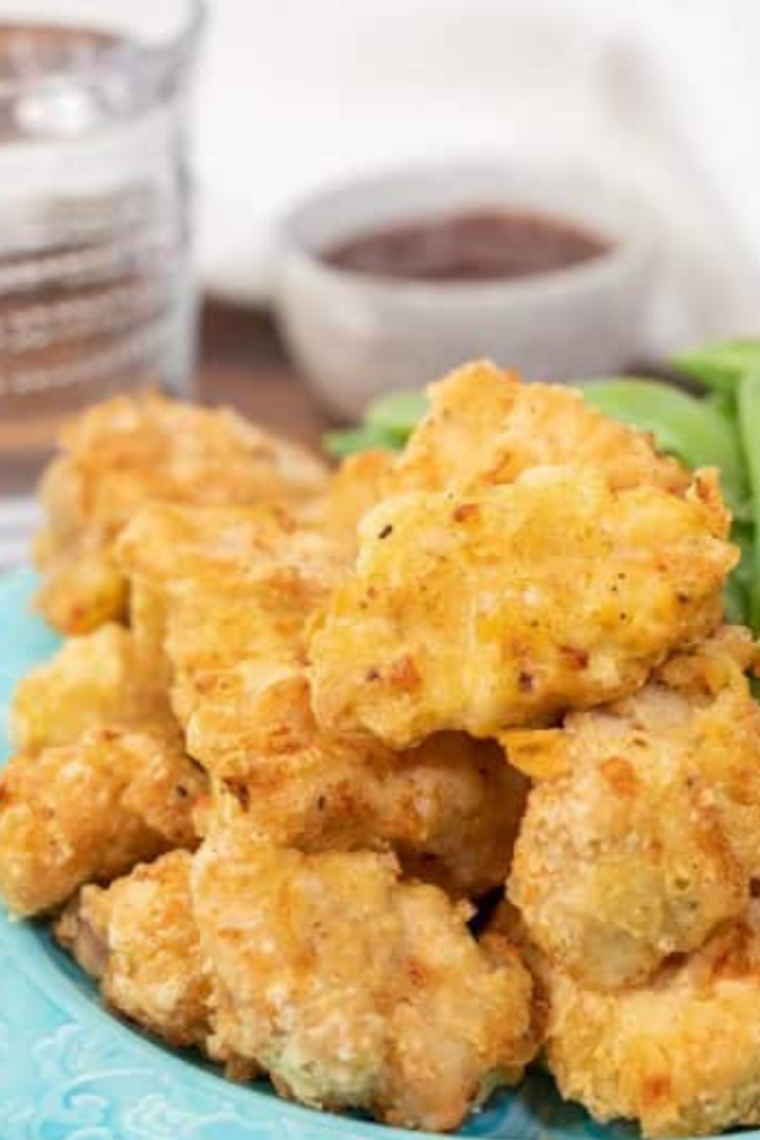 Plate of Chinese Chicken Fingers with dipping sauce in the background.