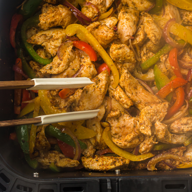 Air fryer fajita vegetables checked for doneness with tender peppers and lightly caramelized onions.