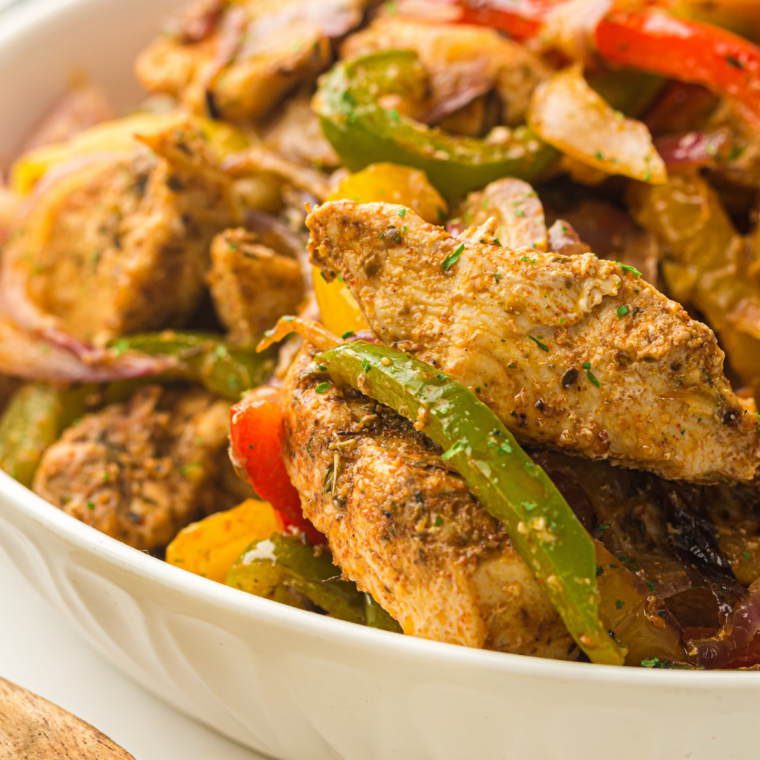 Air fryer fajita vegetables with sliced bell peppers and onions served in a bowl.