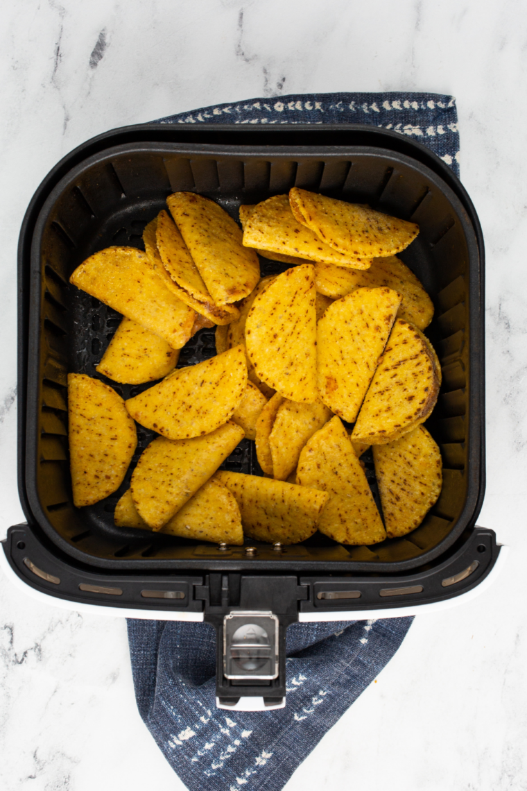 frozen mini tacos arranged in single layer inside air fryer basket