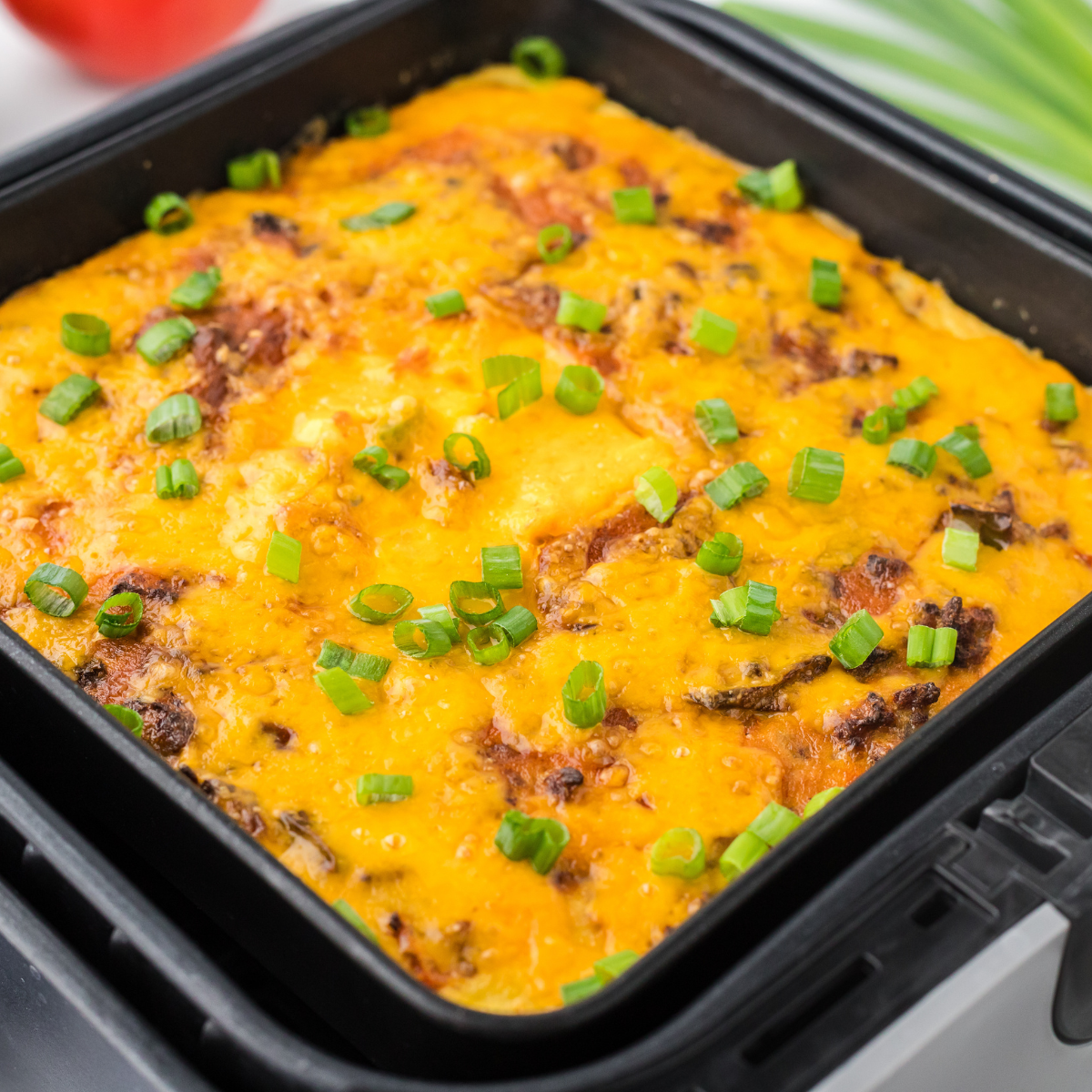 A crispy and cheesy Air Fryer Taco Casserole loaded with seasoned ground beef, melty cheese, and taco toppings, served in a baking dish.