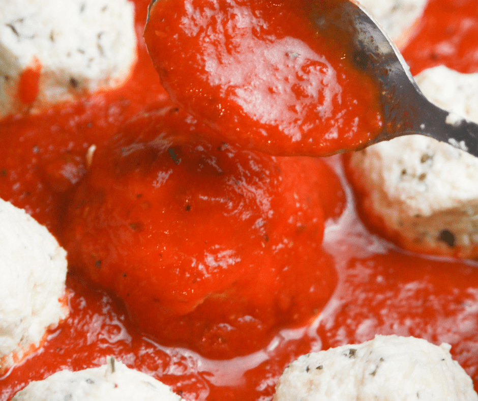 Golden-brown ricotta meatballs cooked to perfection in an air fryer, served on a plate with fresh herbs and marinara sauce.