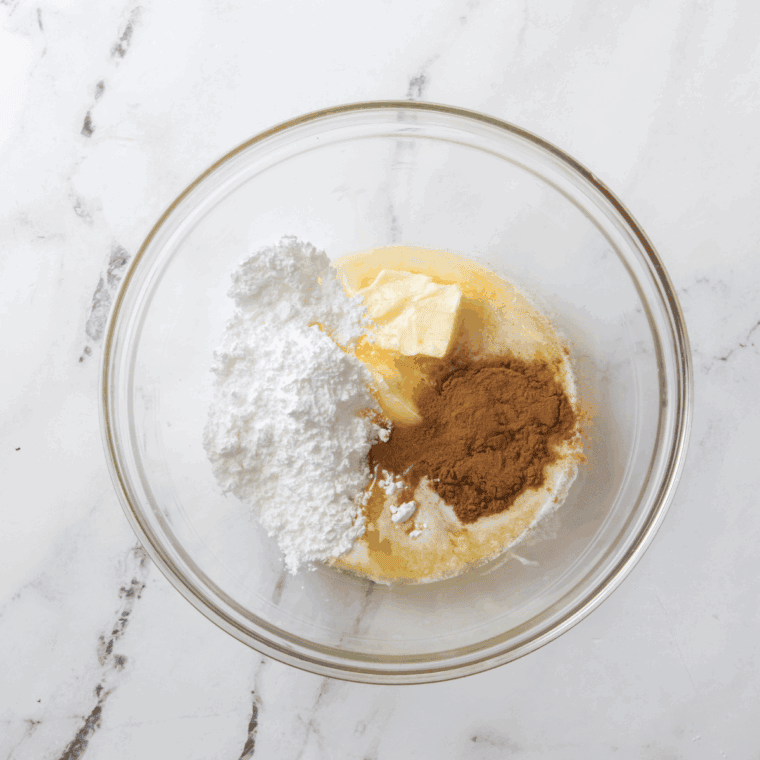 Mixing softened butter, powdered sugar, honey, cinnamon, and vanilla extract in a medium bowl.