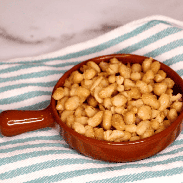 Crispy air fryer cannellini beans in a white bowl after cooking, golden brown and blistered