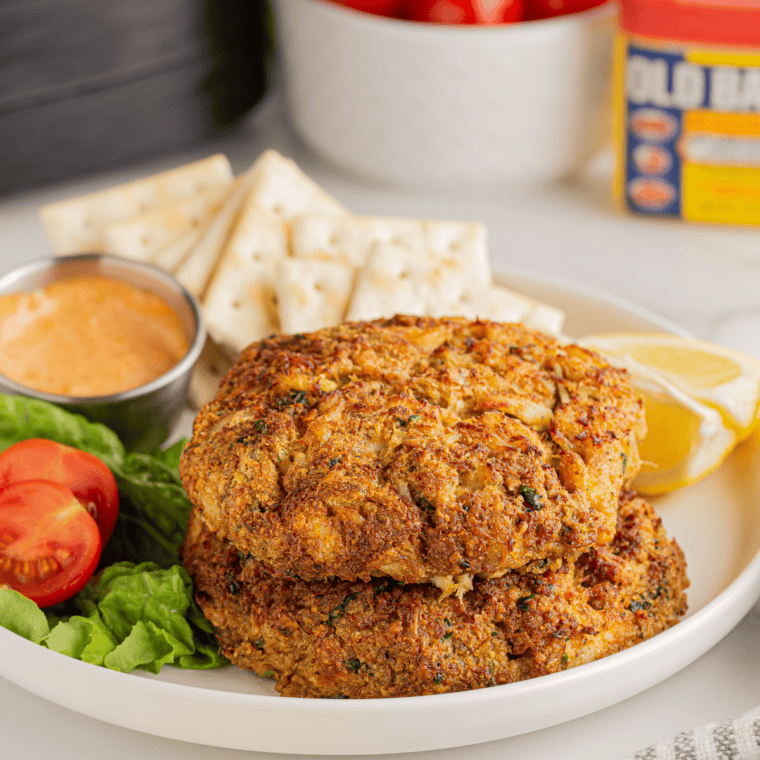Frozen crab cakes air frying until golden brown in basket
