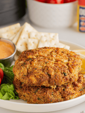 Frozen crab cakes cooking in air fryer basket, golden brown and crispy edges