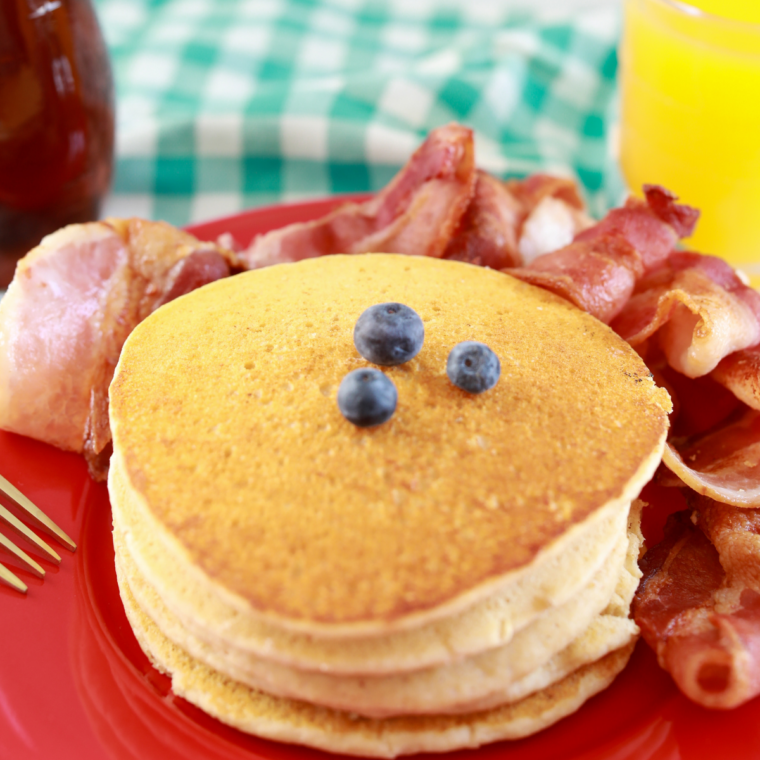 Golden pancakes warming in skillet with butter melting on top