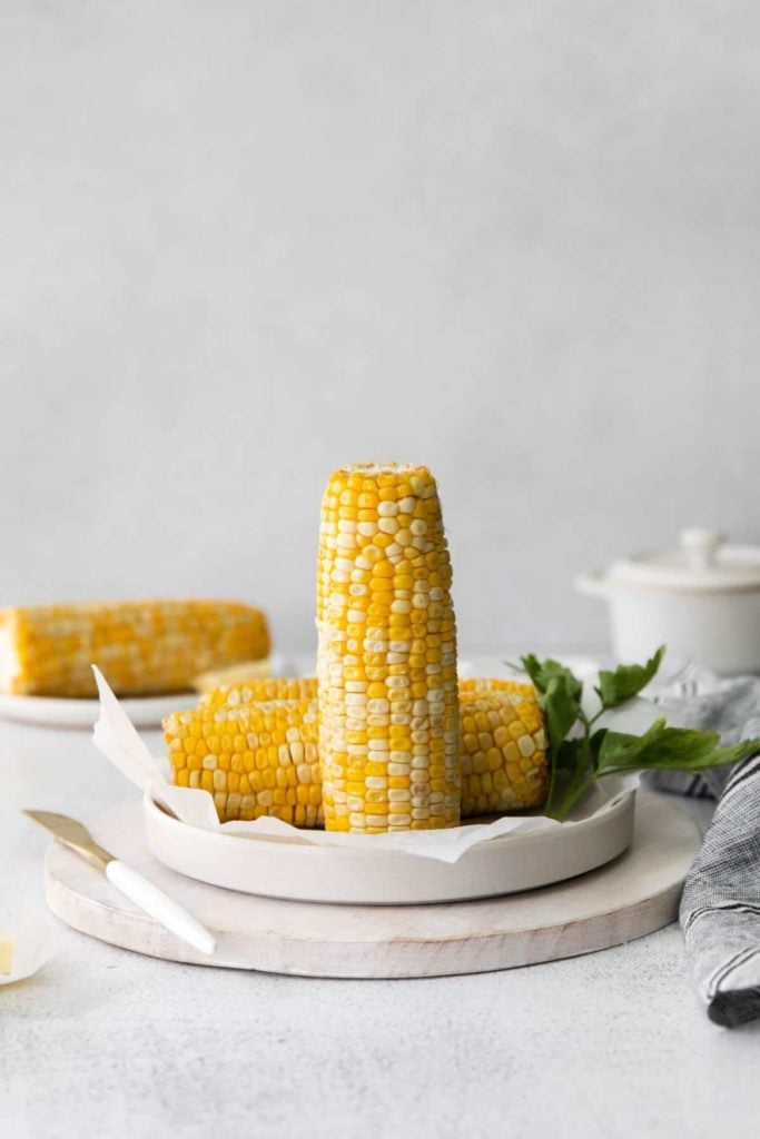 air fryer corn on the cob on a white table setting