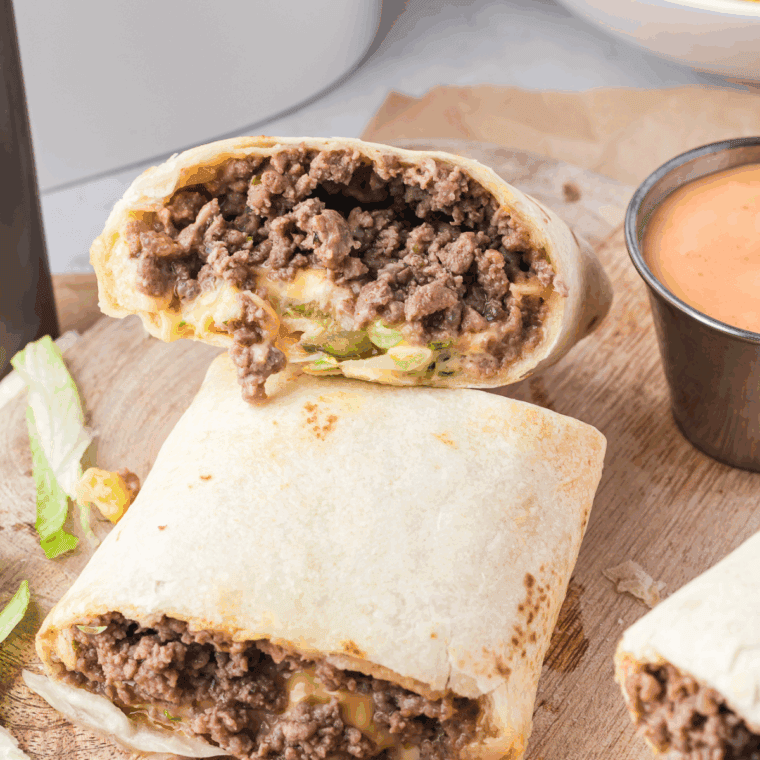 Copycat Big Mac Sauce in a bowl with a spoon and burger toppings nearby.