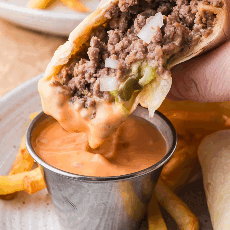 Homemade copycat Big Mac Sauce in a small bowl with a spoon, surrounded by burger toppings.