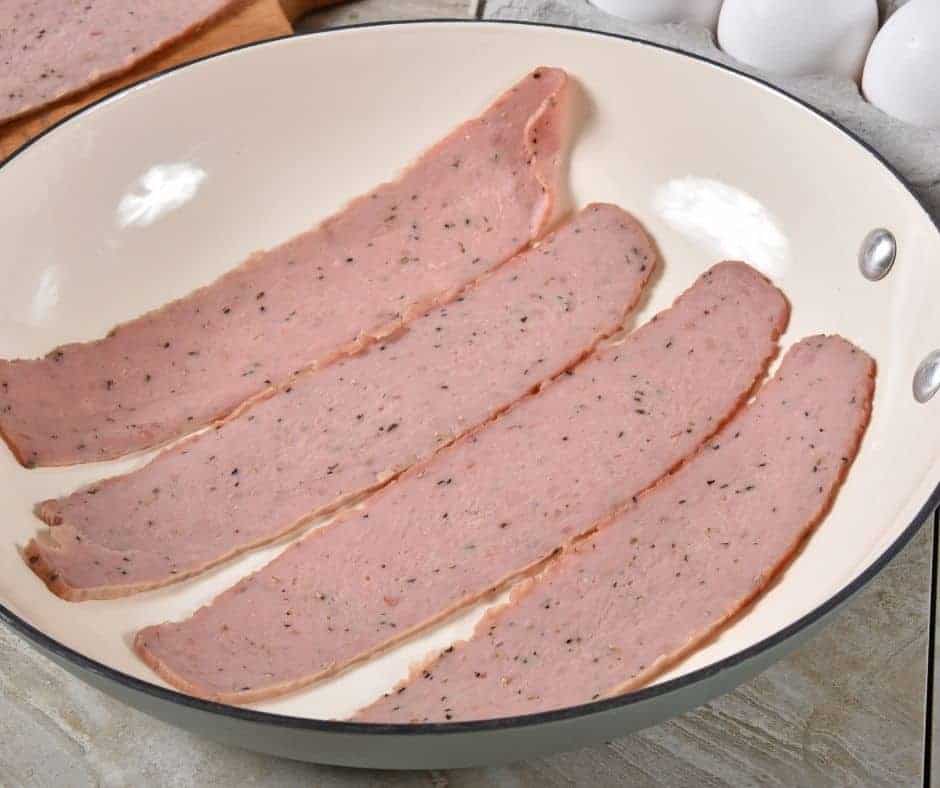 uncooked strips of turkey bacon in a shallow bowl