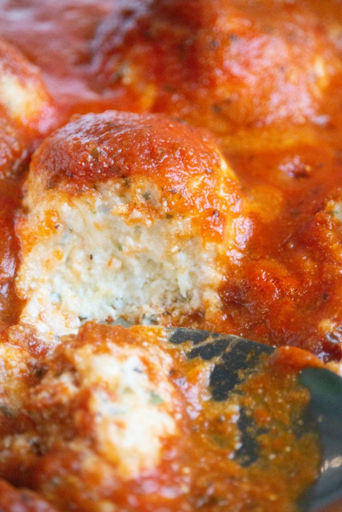 A plate of golden air-fried meatballs with ricotta meatballs with salty pasta sauce.