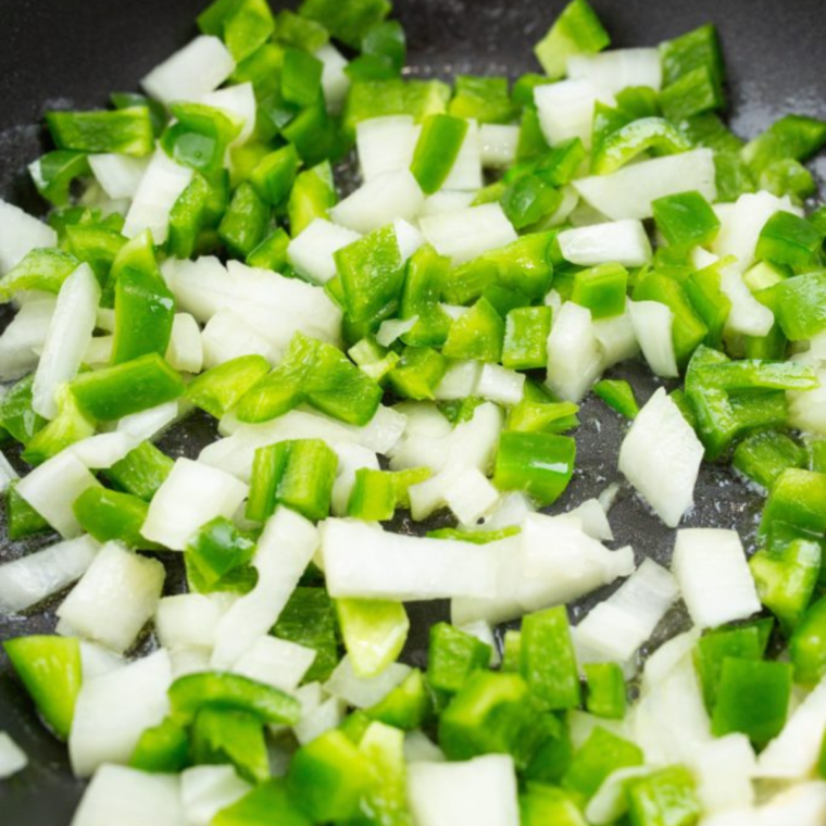 Preparing the ingredients for Air Fryer Chicken Burritos, including shredded chicken, sautéed peppers, and seasonings in bowls