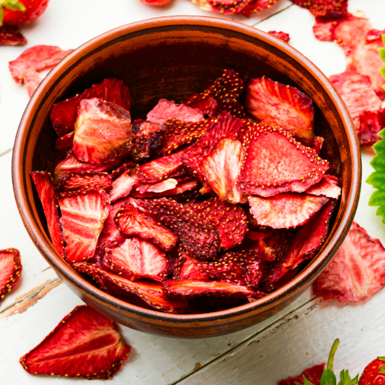 Bowl of air fryer dehydrated strawberries, showcasing their crispy texture and vibrant color.