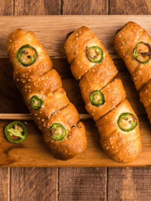 Golden air fryer pretzel cheese dogs on a plate with queso dip