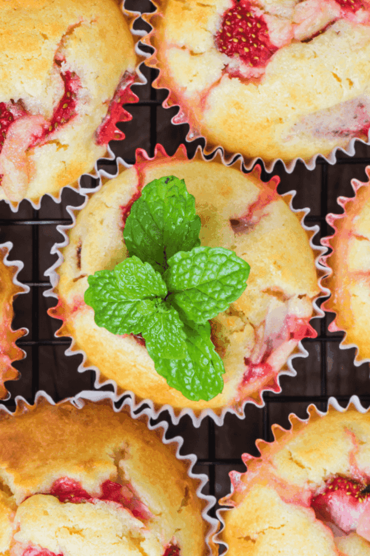 Golden air fryer strawberry muffins with soft, fluffy centers and fresh strawberry pieces