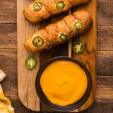 Bowl of creamy beer cheese dip served with soft pretzels for dipping