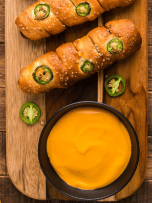 Bowl of creamy beer cheese dip served with soft pretzels for dipping