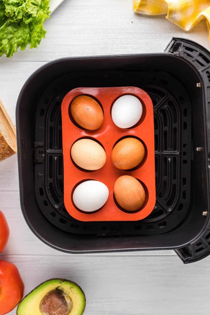 Set your eggs in a trivet or tray, anything to prevent them from flying around the air fryer. Place your temperature to 250 degrees F, air fryer setting.  Set your time for 16 minutes