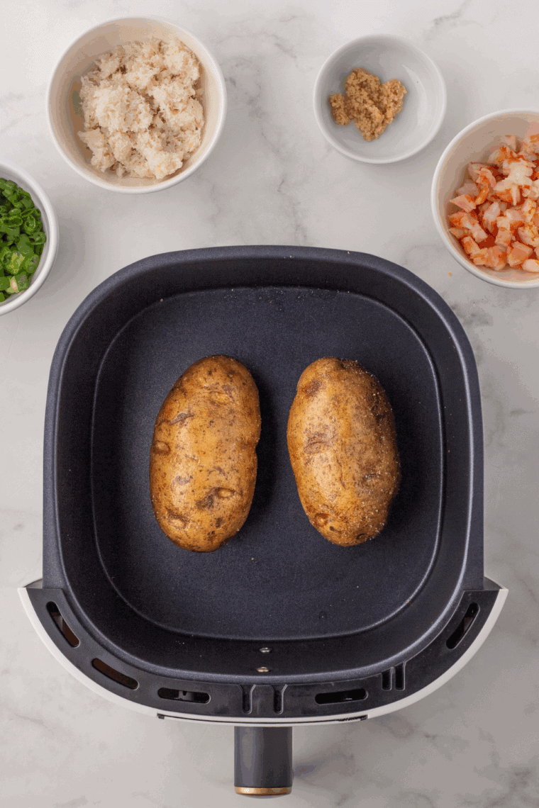Place seasoned baked potato into the air fryer basket.