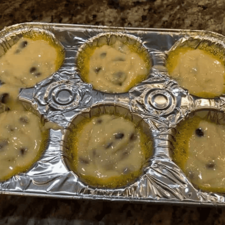 Folding grated carrots, apple, raisins, and coconut into morning glory muffin batter