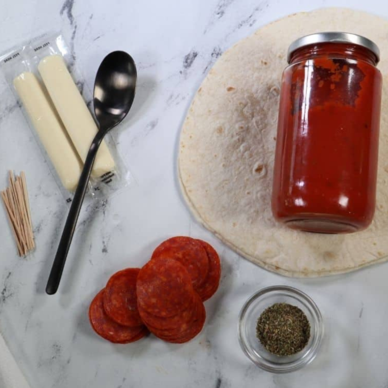 Ingredients for air fryer pizza sticks: pizza dough, cheese, pepperoni, and marinara sauce.