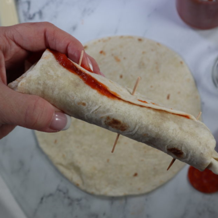 Roll up the tortilla, and then place toothpicks into them, to keep it together. 