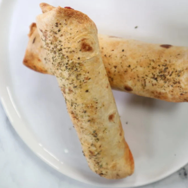 Golden brown air fryer pizza sticks served with marinara sauce for dipping.