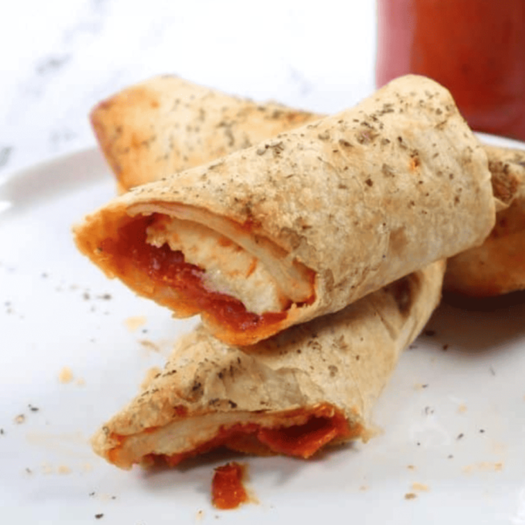 Golden brown air fryer pizza sticks served with marinara sauce for dipping.