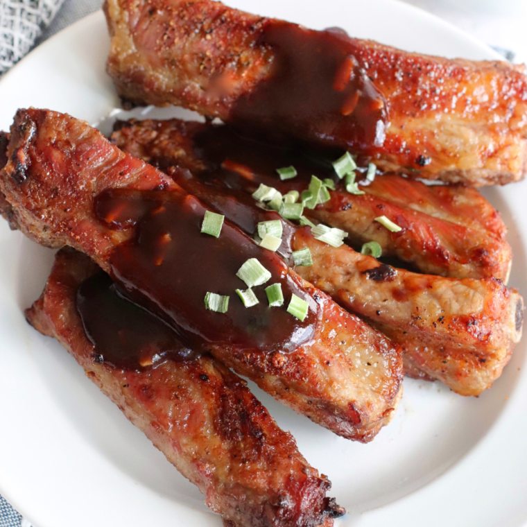 Plate of Air Fryer Fireball Glazed Ribs with crispy exterior and juicy interior, drizzled with a sweet and tangy Fireball whiskey glaze."