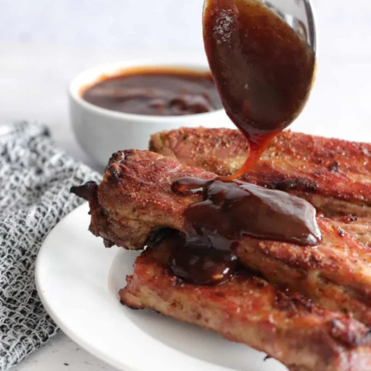 "Ribs cooking in the air fryer, tender and golden brown."