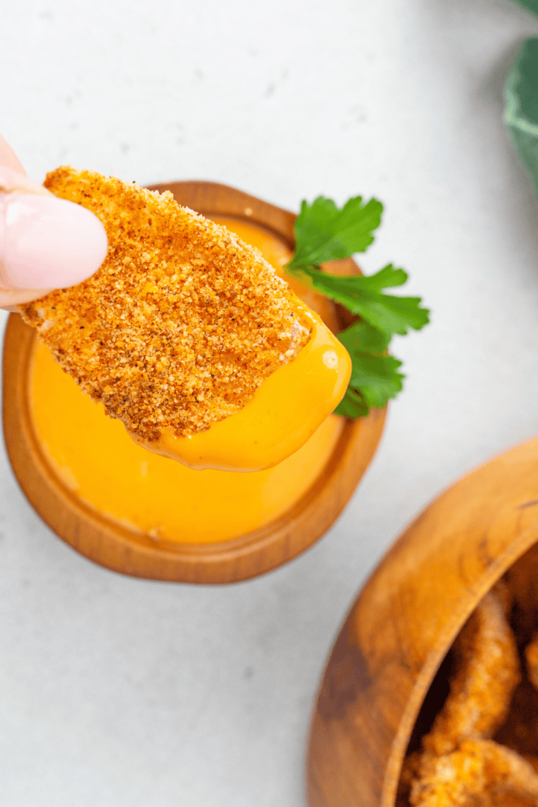 Creamy horseradish dipping sauce in a small bowl beside crispy air fryer onion petals