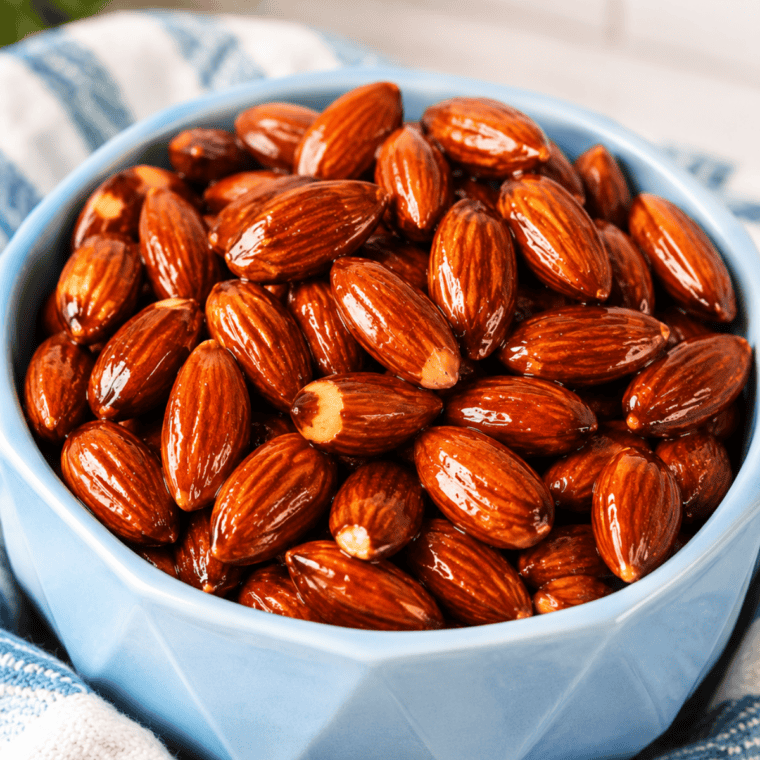 Air fryer honey roasted almonds cooling on a parchment-lined tray
