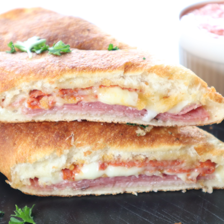 Air Fryer Italian Stromboli with crispy golden crust and melted cheese inside, filled with ham, salami, pepperoni, and provolone cheese.