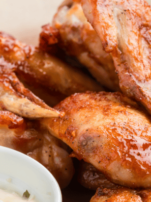 Crispy Wingstop-style mild chicken wings coated in buttery sauce served on a plate with dipping sauce.