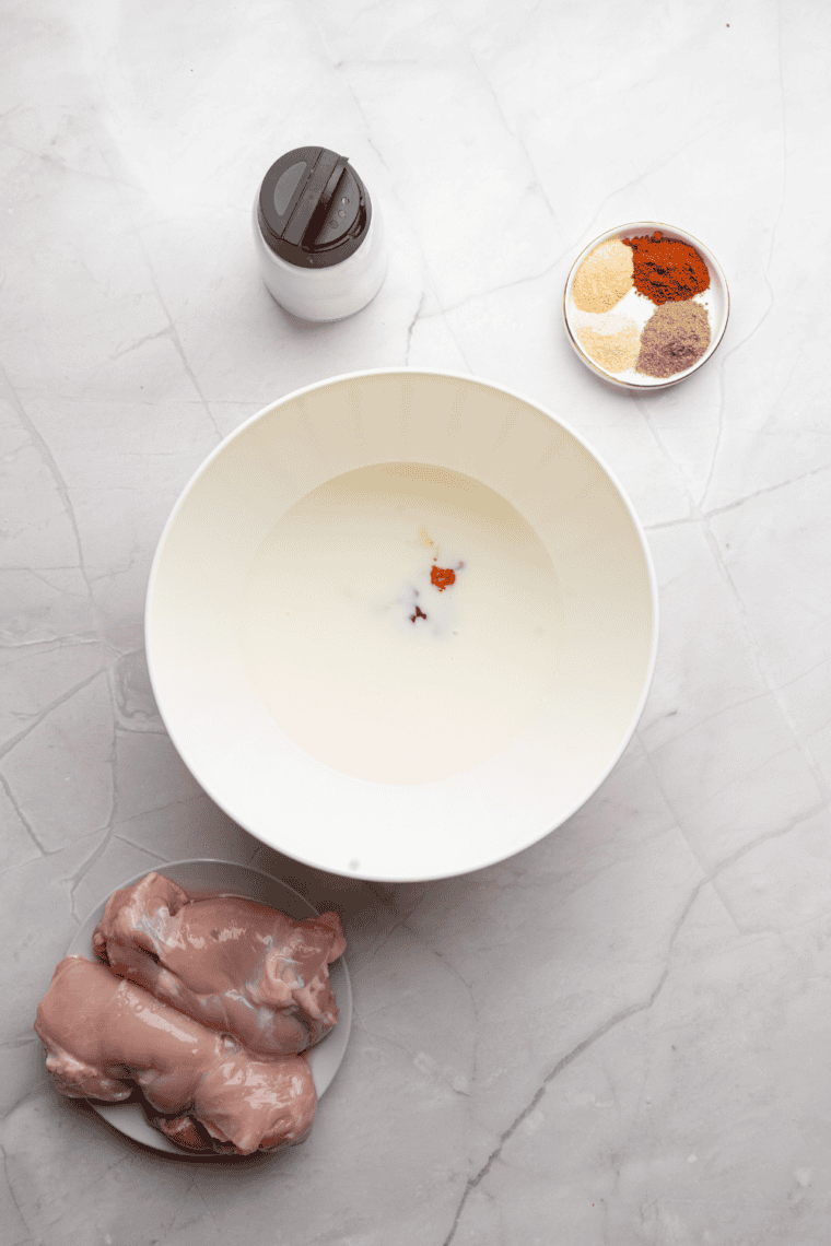 Chicken breasts and thighs being patted dry with paper towels before cooking.