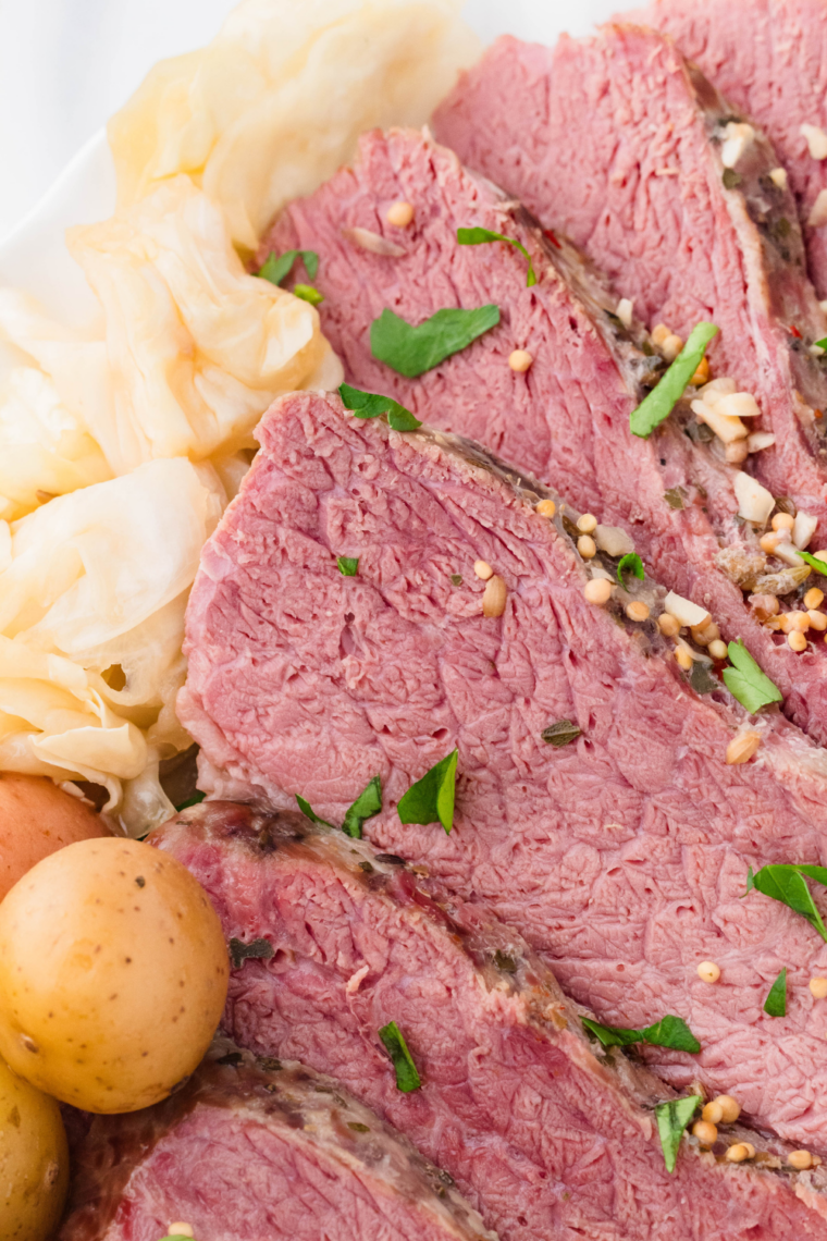 Close-up of air fryer corned beef brisket slices with golden crust and juicy interior served on a plate.