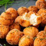 Crispy golden Cheesecake Factory Loaded Baked Potato Tots topped with melted cheese, bacon bits, and green onions